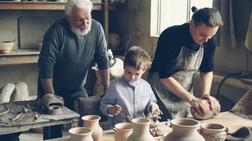 Elder, adult, and child working together in a pottery workshop, crafting ceramics.